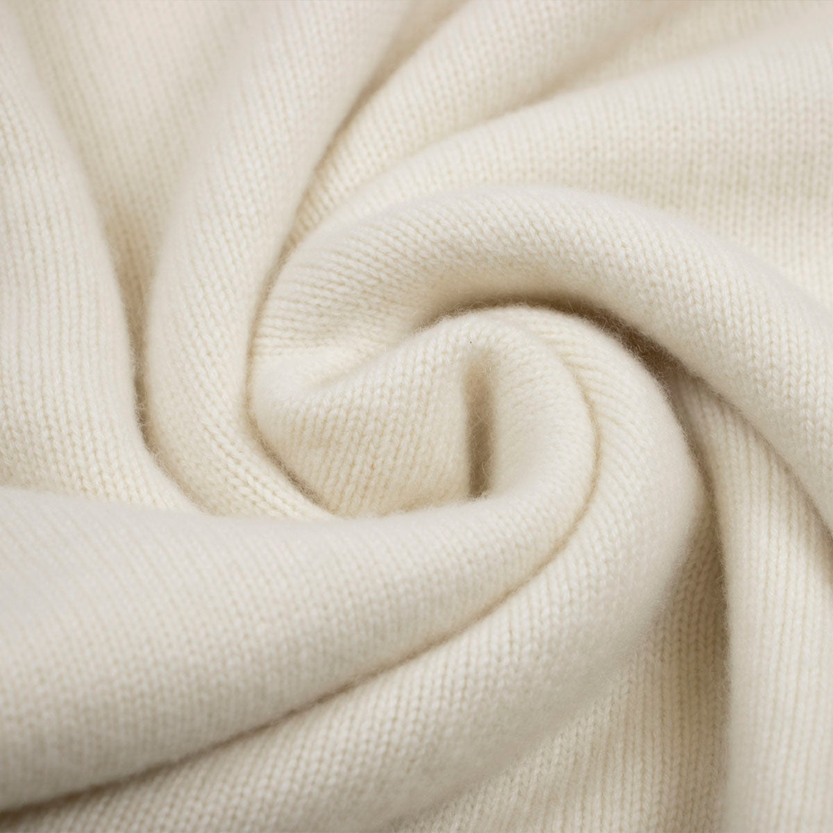 A close up of a white, undyed Portree sweater.
