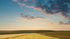 A late summer sunset over a field of crops