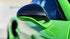 A green supercar in close-up on the wing mirror and trailing body