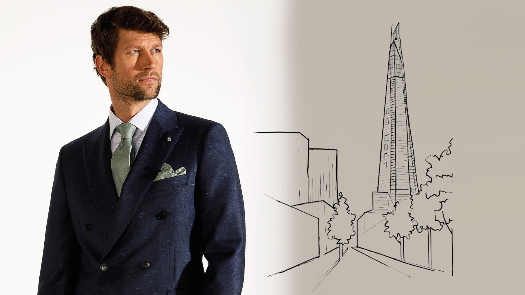 Man in a navy suit standing next to a line drawing of a skyscraper.